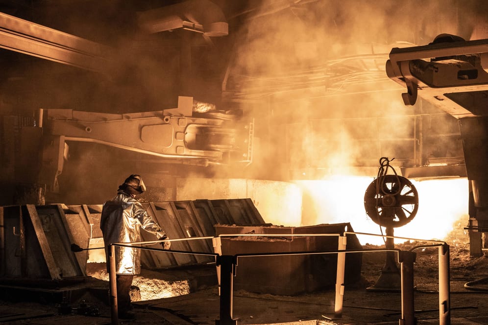 Ein Mitarbeiter eines Stahlwerks beaufsichtigt den Schmelzvorgang (Archivbild): Die Beschäftigten der Metall- und Elektroindustrie kämpfen für einen Inflationsausgleich.