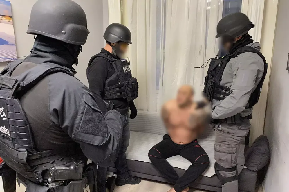 Berliner Polizisten mit festgenommenem Mann: Ein Ehepaar soll das kriminelle Netzwerk geführt haben.