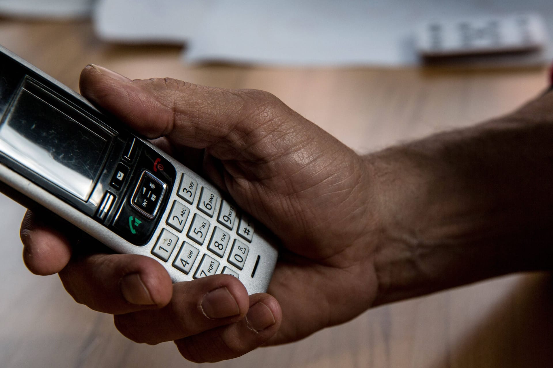 Eine Person hält ein Telefon in der Hand (Symbolbild): Die Polizei warnt vor betrügerischen Anrufen.