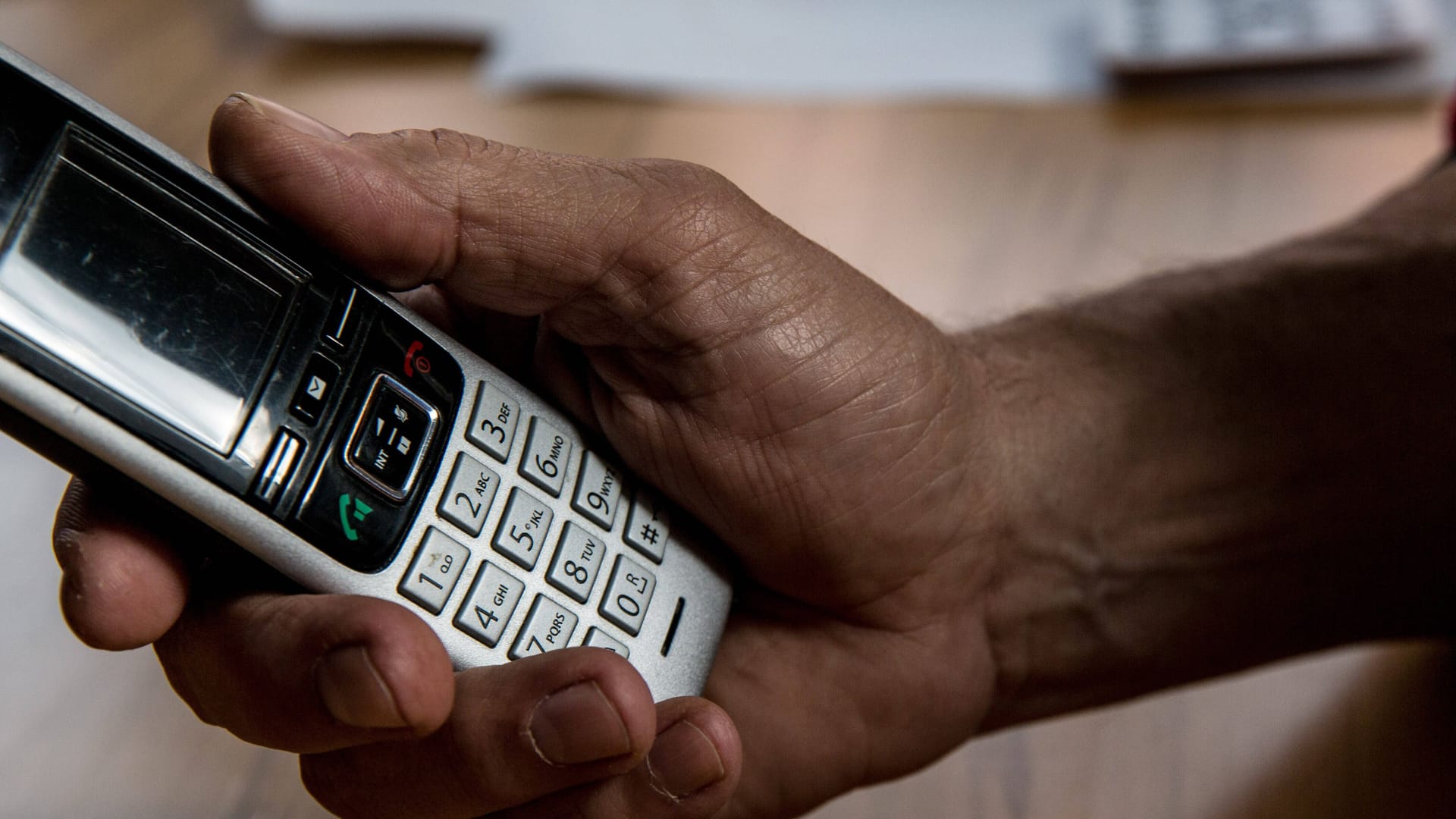 Eine Person hält ein Telefon in der Hand (Symbolbild): Die Polizei warnt vor betrügerischen Anrufen.