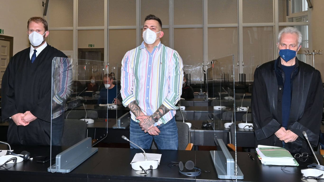 Der Hamburger Rapper Gzuz steht neben seinen Anwälten im Gericht (Archivbild): Seine Verurteilung ist rechtskräftig.