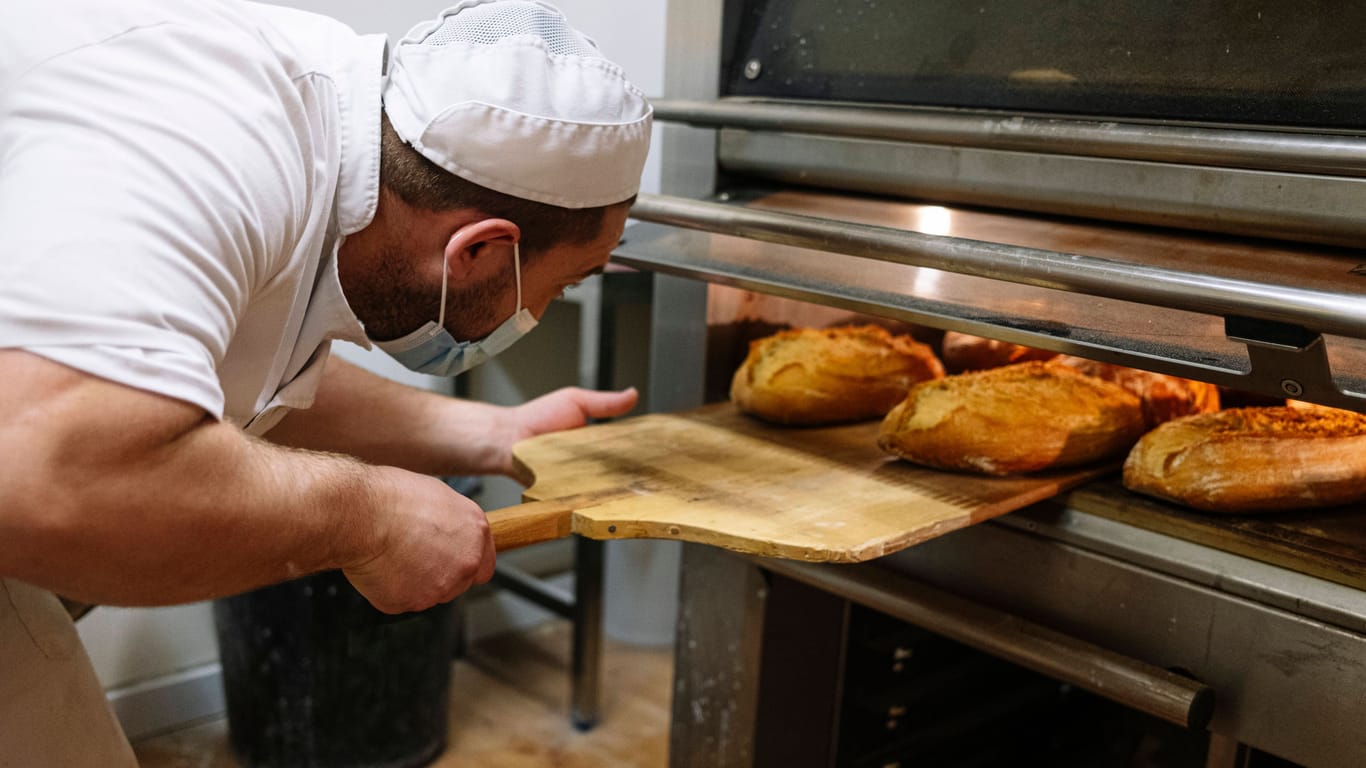 Ein Bäcker holt Brote aus dem Ofen (Symbolbild): Viele Bäckereien haben sich den Hilferufen angeschlossen.