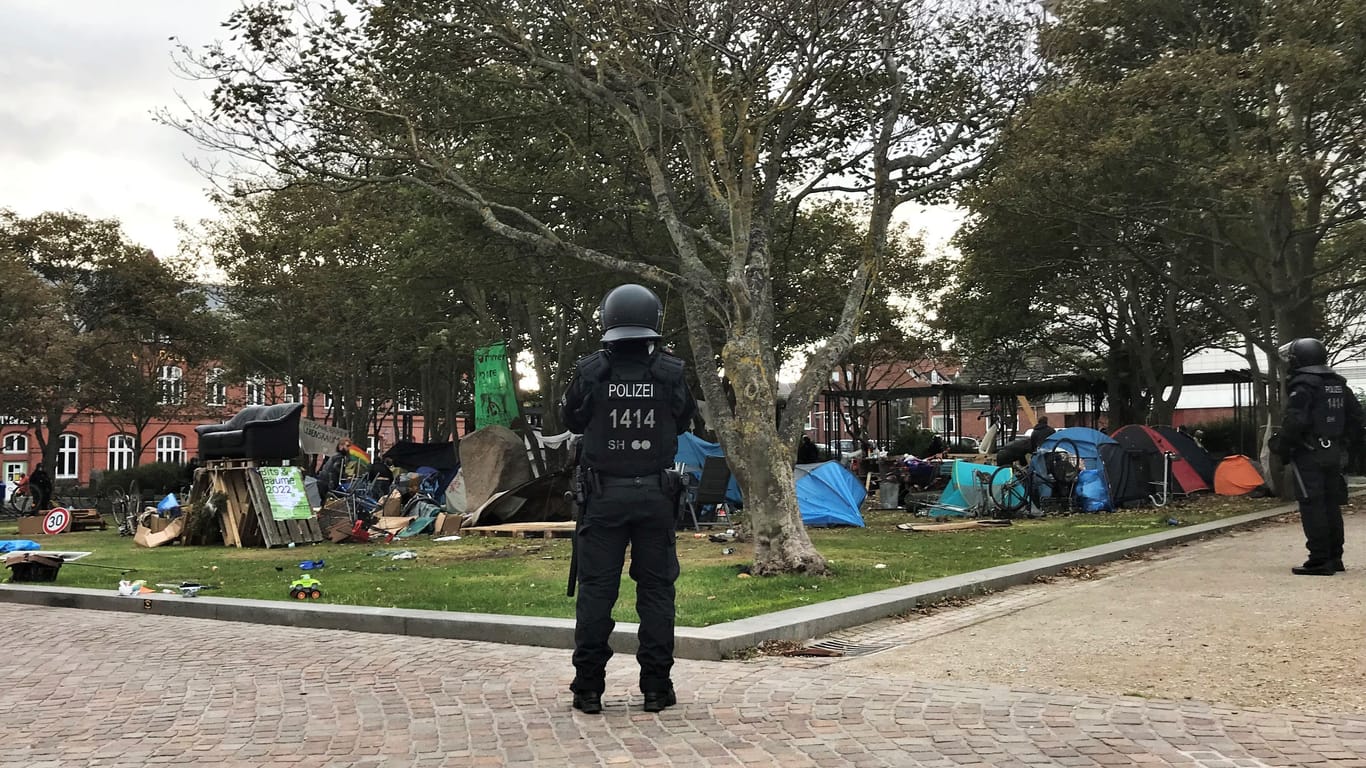 Polizisten mit Helmen umstellen das Camp im Rathauspark: Wenn es nach den örtlichen Behörden geht, sollen die Punks die Insel Sylt verlassen.