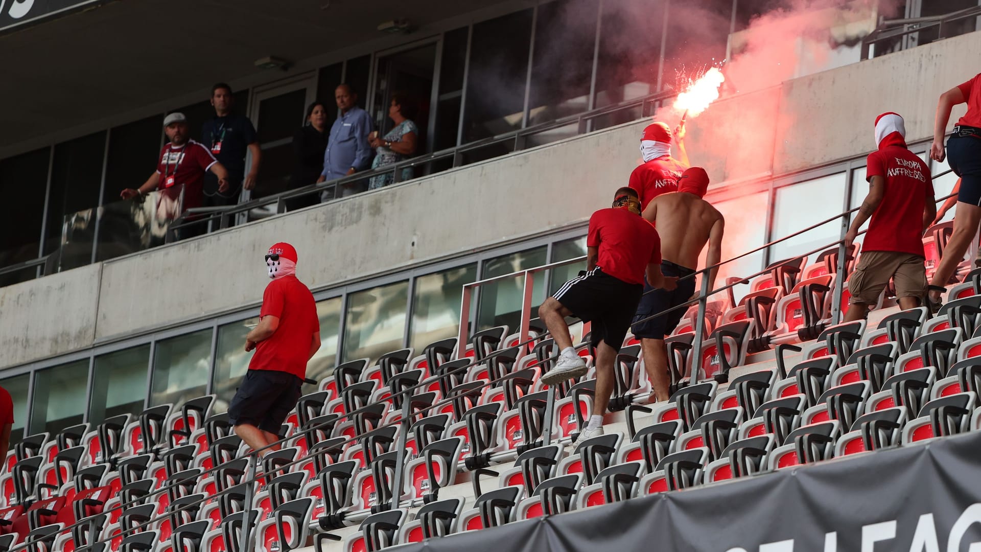 Baumgart steht links oben: Unter ihm sind Hooligans zu sehen.