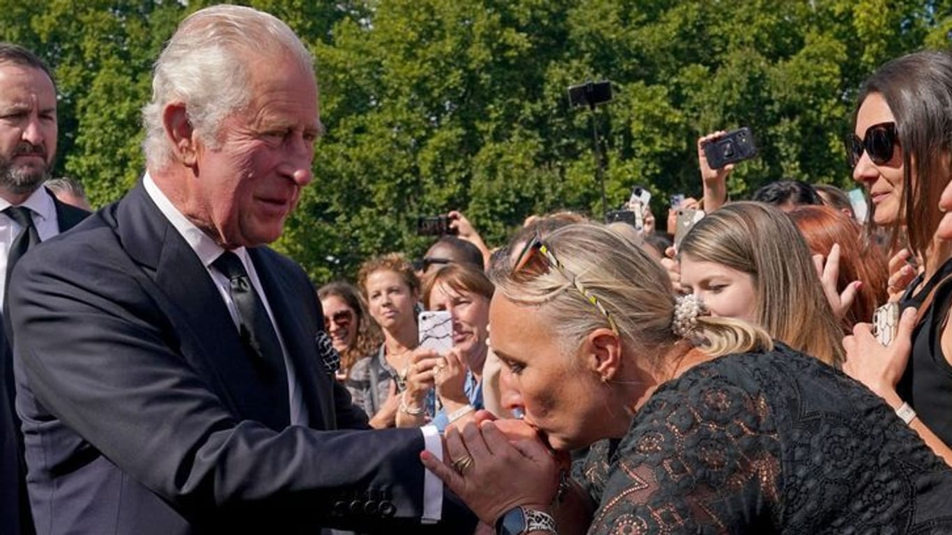 Der neue König: Eine Frau küsst die Hand von König Charles III. bei seinem Rundgang vor dem Buckingham-Palast in London.