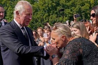 Der neue König: Eine Frau küsst die Hand von König Charles III. bei seinem Rundgang vor dem Buckingham-Palast in London.