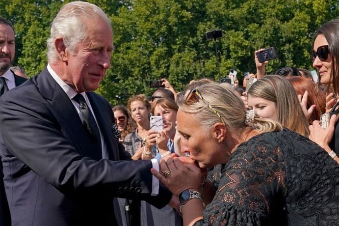 Der neue König: Eine Frau küsst die Hand von König Charles III. bei seinem Rundgang vor dem Buckingham-Palast in London.