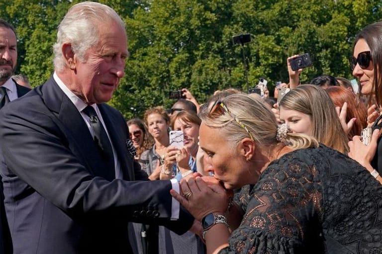 Der neue König: Eine Frau küsst die Hand von König Charles III. bei seinem Rundgang vor dem Buckingham-Palast in London.
