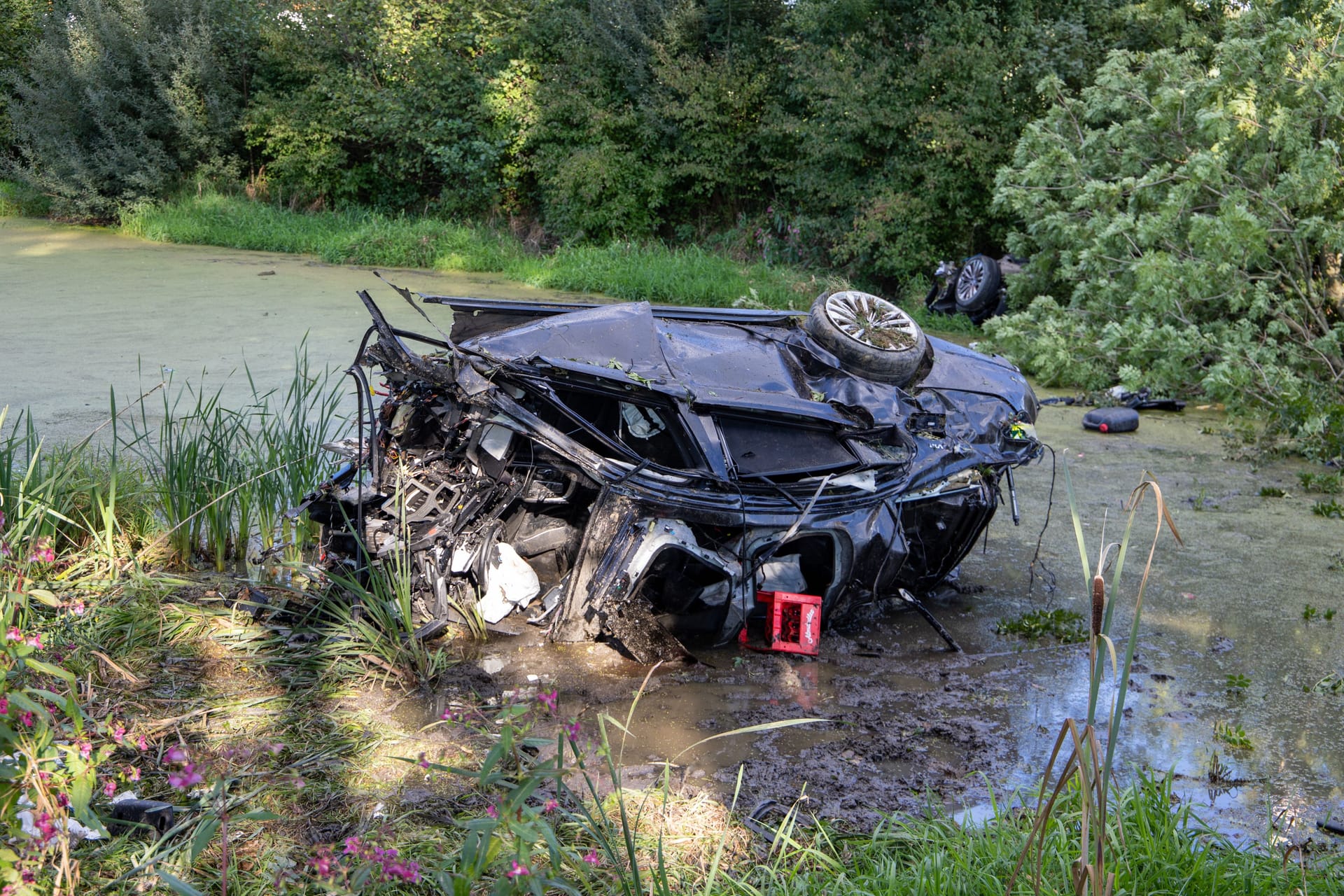 Der nicht mehr erkennbare BMW: Ein großes Wrackteil landete einige Meter weiter im Gebüsch.