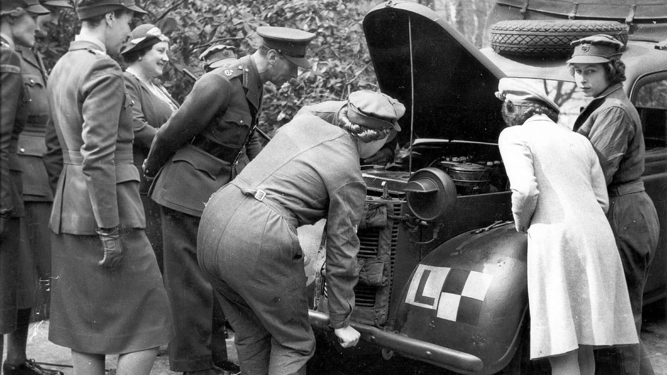 Bei der Arbeit: Beim Besuch ihres Vaters George VI., ihrer Mutter und ihrer Schwester Prinzessin Margaret zeigte die spätere Königin Elizabeth im April 1945 ihre Fähigkeiten als Automechanikerin.