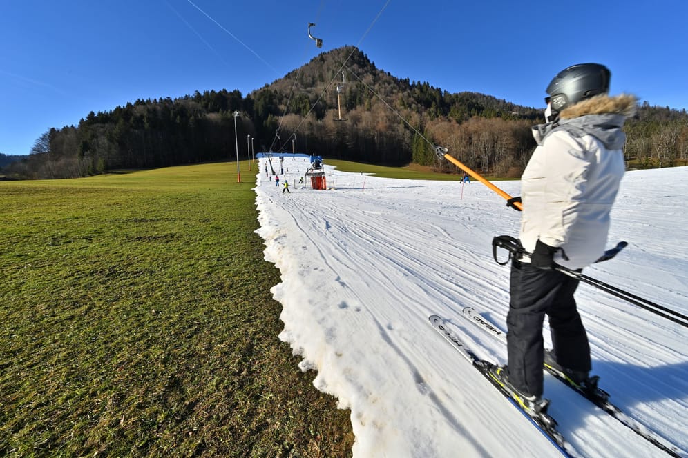 Ein Skilift über grüner Wiese bei Ruhpolding (Archivbild): So wie hier ist mittlerweile auch im Winter oft Kunstschnee nötig – der viel Energie kostet.