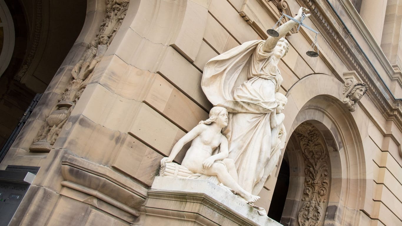 Vor einem Landgericht hält eine Statue der Justitia eine Waagschale (Symbolbild): Der Mann soll die wirtschaftliche Lage der Eltern ausgenutzt haben.