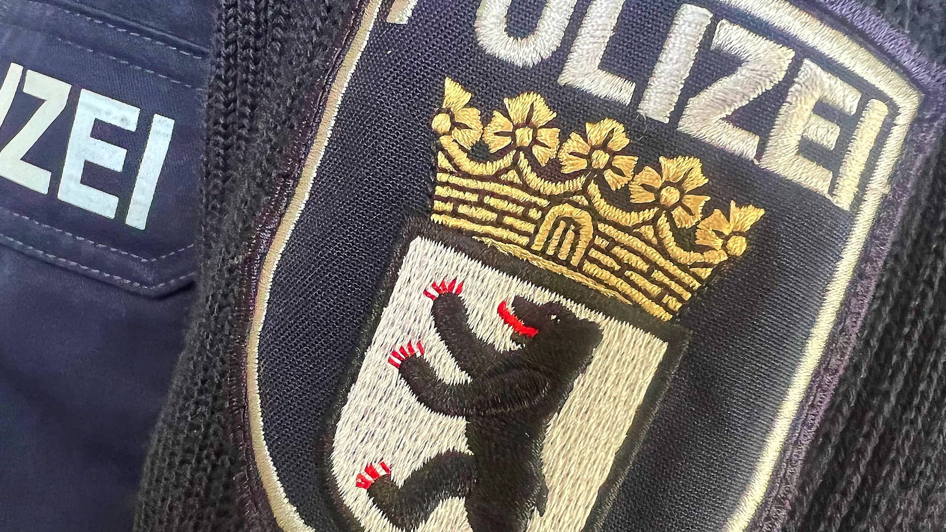 Abzeichen der Berliner Polizei am Ärmel eines Polizisten: Gegen einen Beamten wird wegen "fremdenfeindlicher Beleidigung" ermittelt. Abzeichen der Berliner Polizei am Ärmel eines Polizisten: Gegen einen Beamten wird wegen "fremdenfeindlicher Beleidigung" ermittelt.