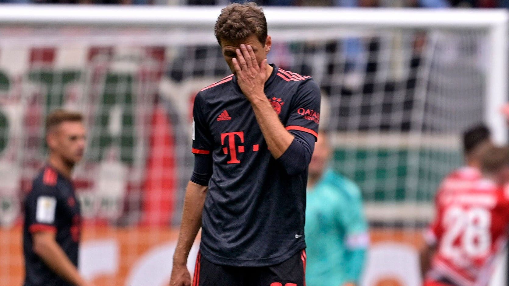 Kann es nicht fassen: Bayerns Thomas Müller verzweifelt, im Hintergrund jubeln die Augsburger.