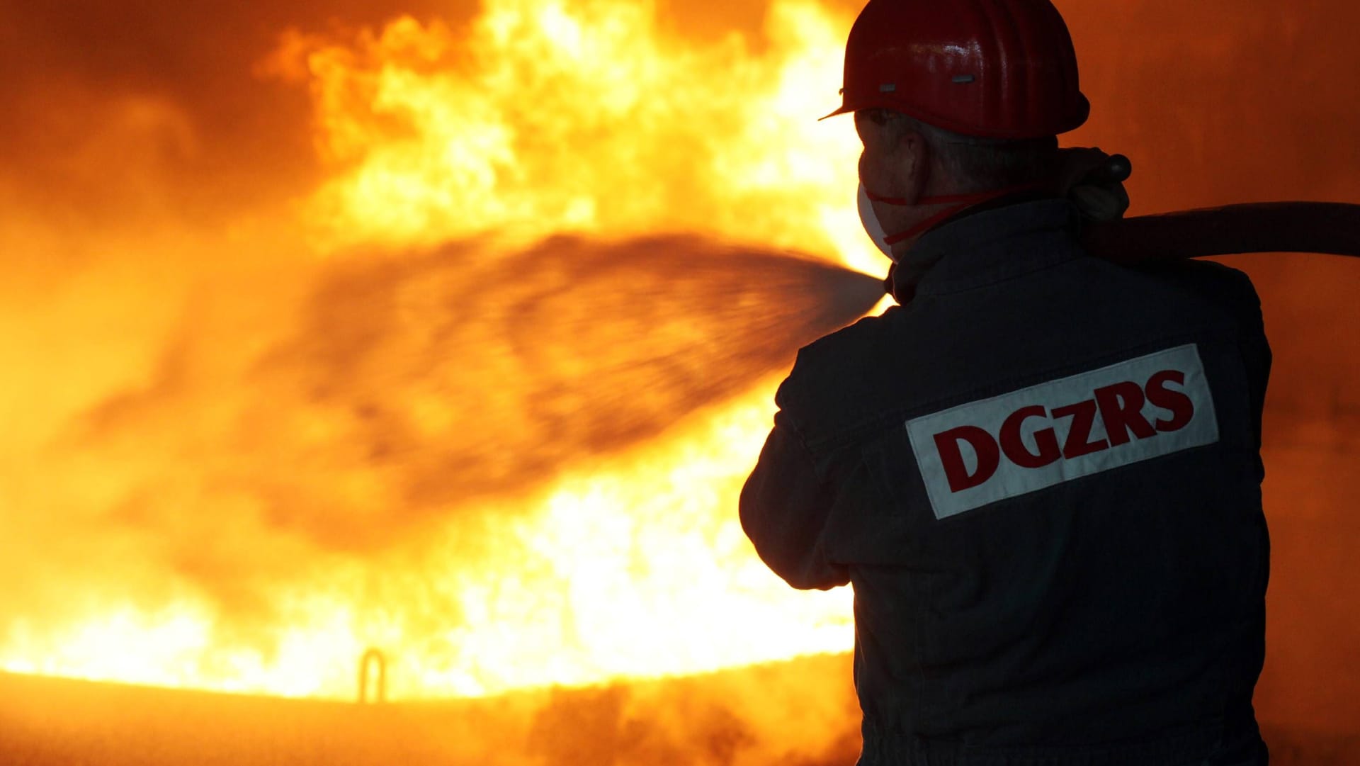 Feuerwehrmann löscht Brand (Symbolbild): In Boltenhagen ist eine Villa durch ein Feuer zerstört worden.