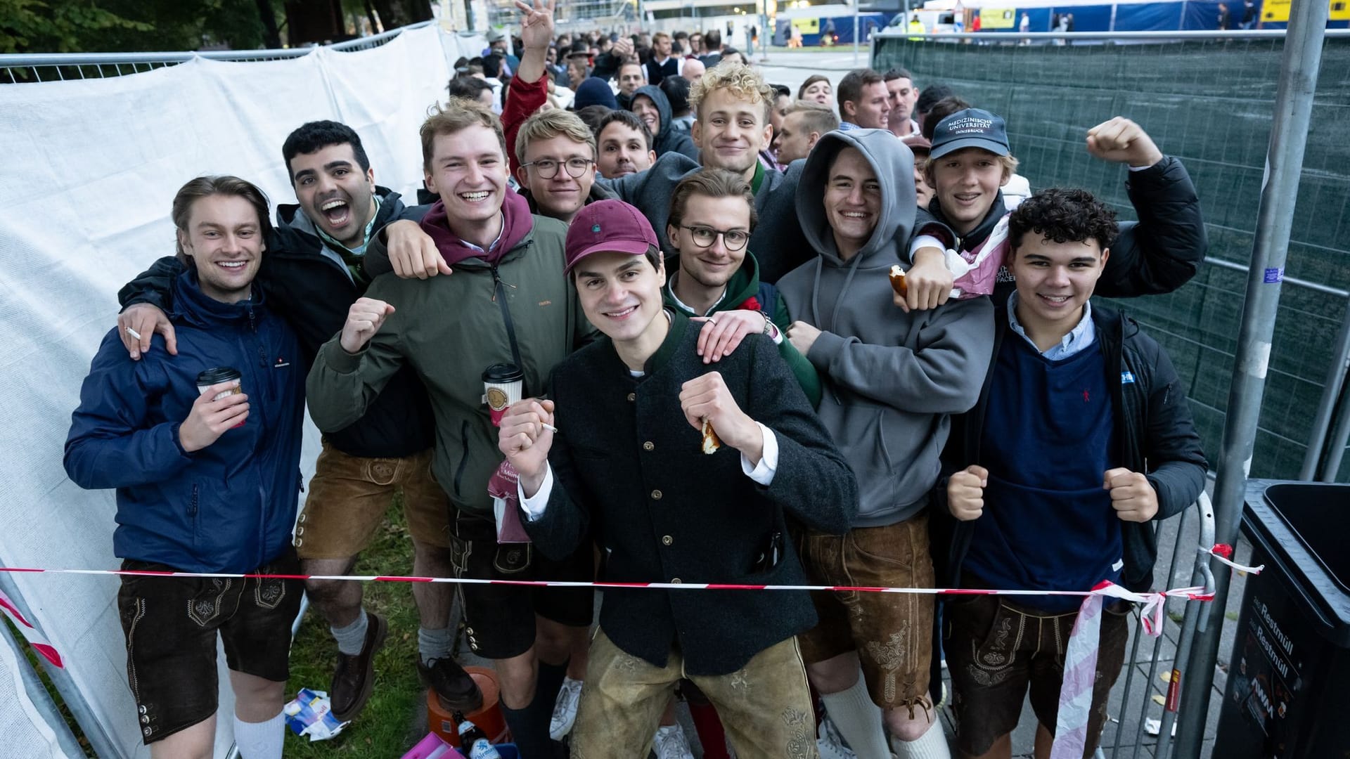 Die ersten Wiesnbesucher stehen am Eingang und warten auf den Einlass.