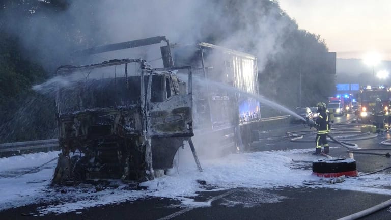Feuerwehrmänner löschen den Brand: Der Lastwagen brannte komplett aus.