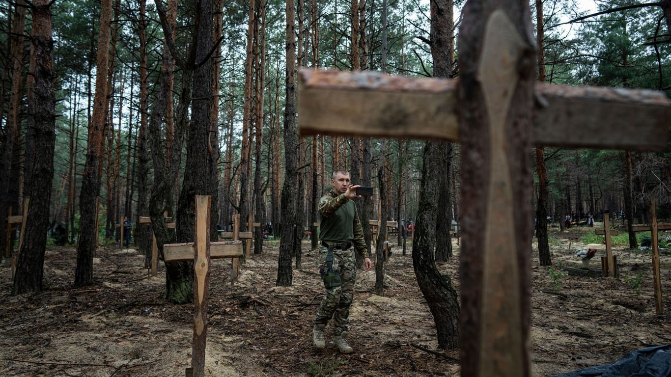 Oleg Kotenko, der Beauftragte für Vermisstenfragen unter besonderen Umständen, filmt die kürzlich entdeckten Gräber bei Isjum.