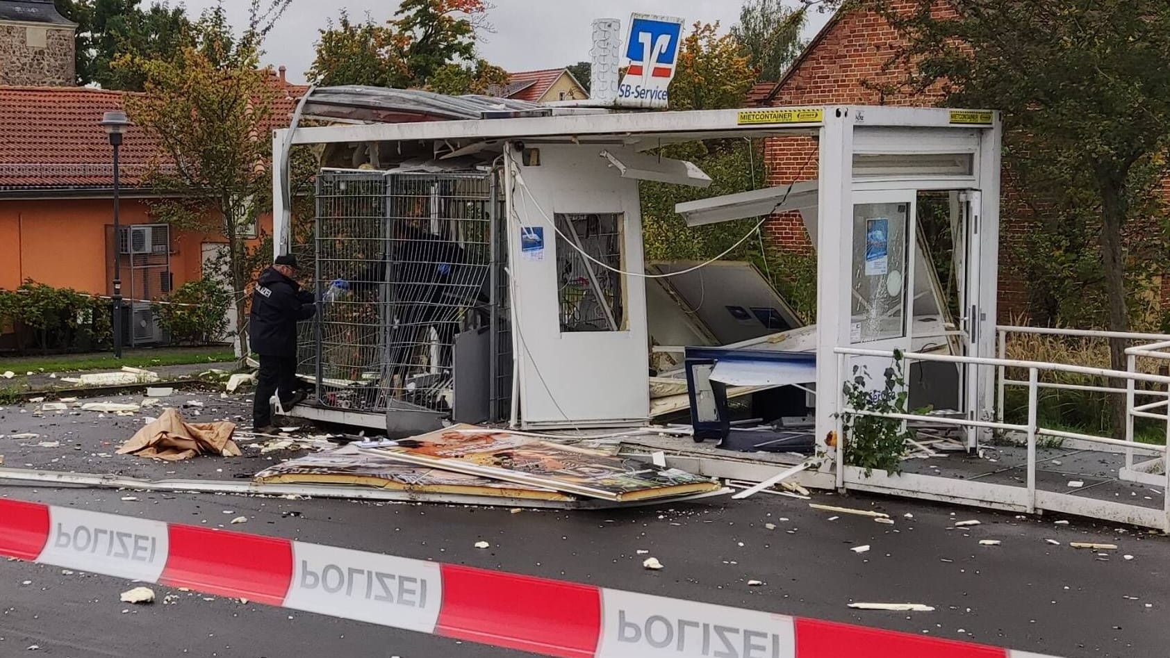 Polizisten sichern Spuren an einem gesprengten Geldautomaten: Die Trümmer waren auf dem Parkplatz des anliegenden Discounters verteilt. Polizisten sichern Spuren an einem gesprengten Geldautomaten: Die Trümmer waren auf dem Parkplatz des anliegenden Discounters verteilt.