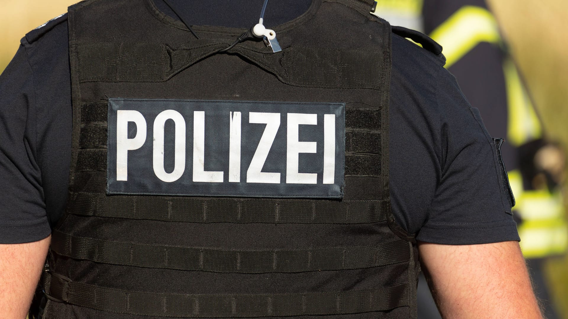 Ein Beamter der Polizei mit Weste (Symbolfoto): Der Vater des angefahrenen Kindes soll unvermittelt auf den Fahrer eingeschlagen haben.