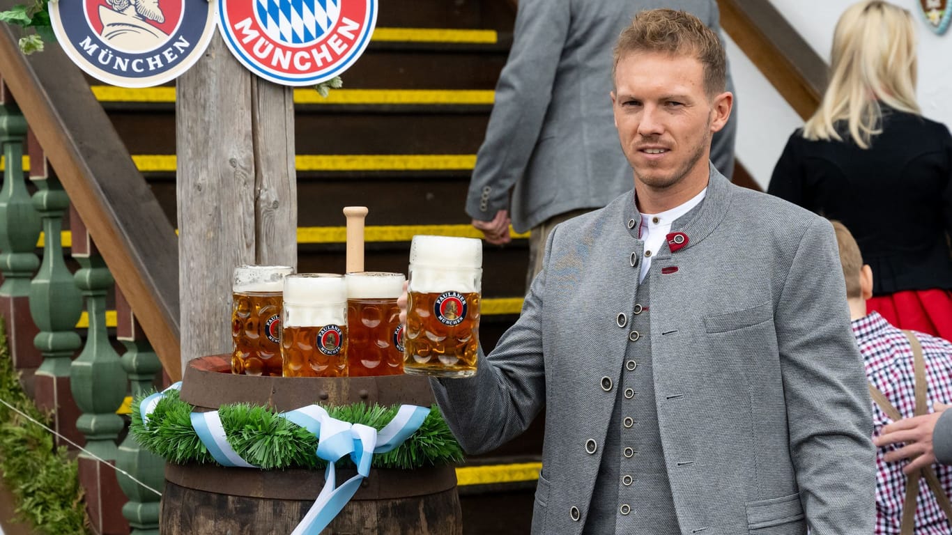 Bayern-Trainer Julian Nagelsmann posiert mit Bier: Nur ein gequältes Lächeln gibt's für die Kameras auf der Wiesn.