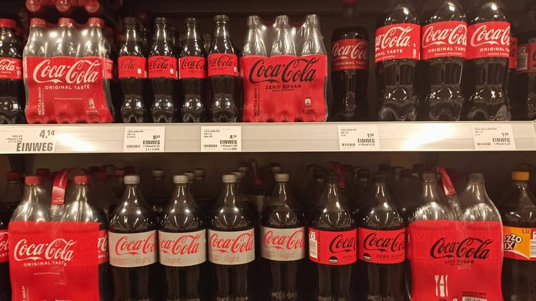 Coca-Cola-Flaschen (Archivbild): Die Lücken in den Getränkeregalen der Supermarktkette Edeka dürften vorerst ein Ende haben.