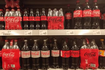 Coca-Cola-Flaschen (Archivbild): Die Lücken in den Getränkeregalen der Supermarktkette Edeka dürften vorerst ein Ende haben.