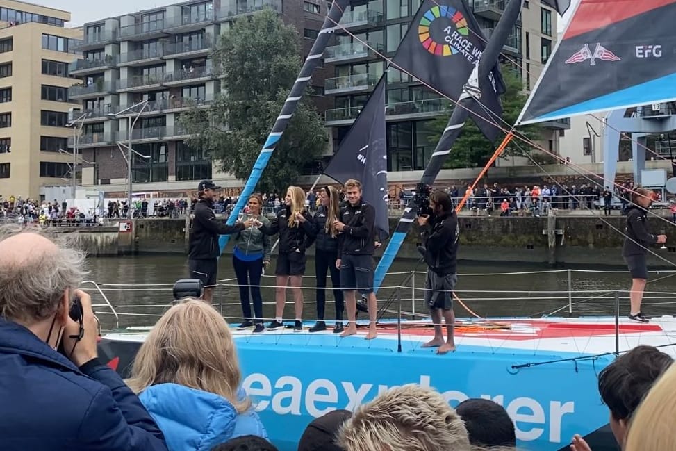 Boris Herrmann und sein Team stehen auf der "Malizia - Seaexplorer" uns stoßen an.