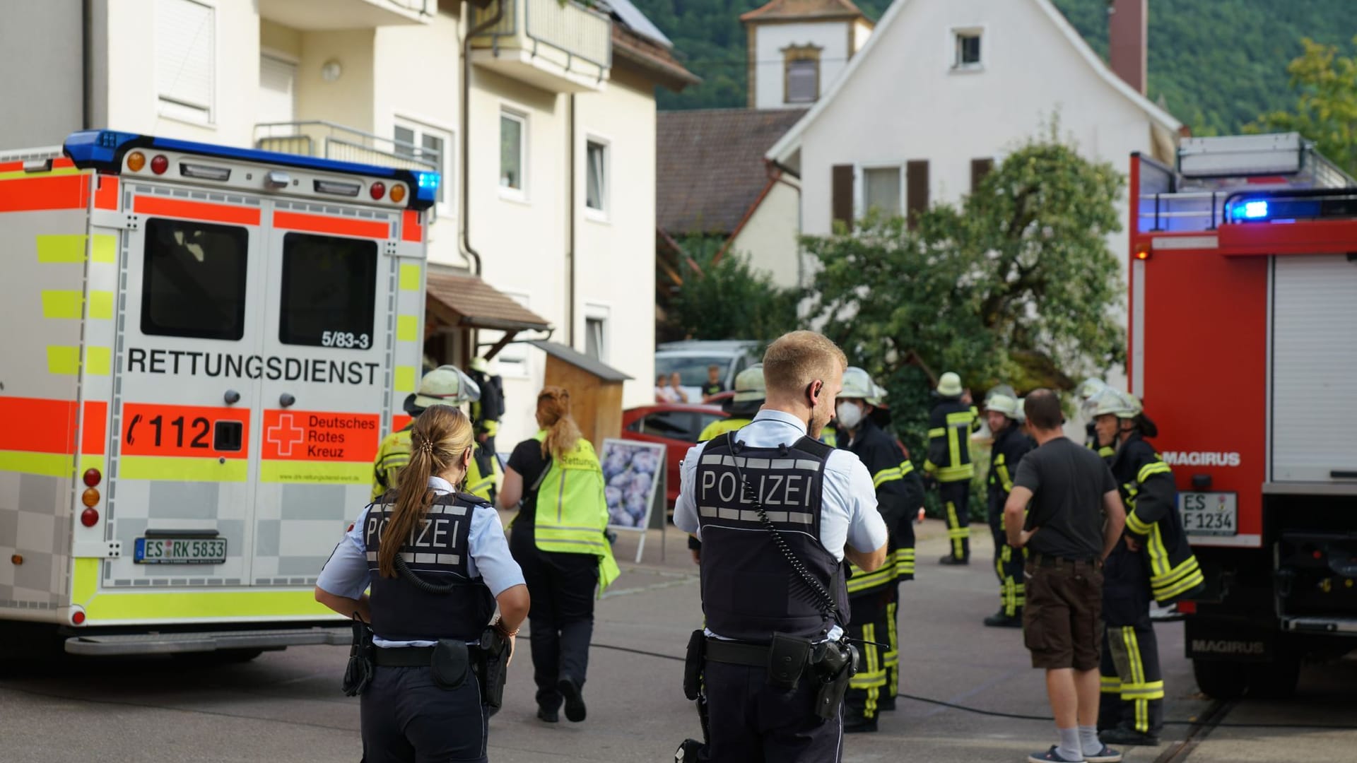 Polizei und Rettungskräfte stehen nahe des Unfallortes in einem Wohngebiet: Für den Mann kommt jede Hilfe zu spät, die Frau kommt schwer verletzt ins Krankenhaus.