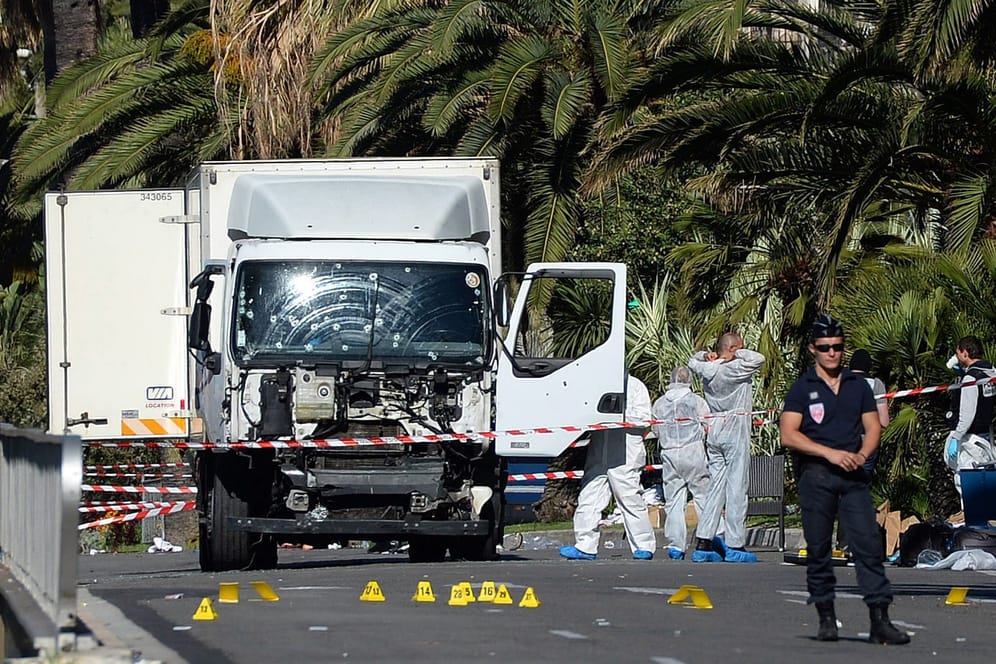 Polizisten stehen um den Lastwagen (Archivbild): Damit raste der Attentäter beim Anschlag am Nationalfeiertag in Nizza mit einem LKW in eine Menschenmenge an der Strandpromenade.