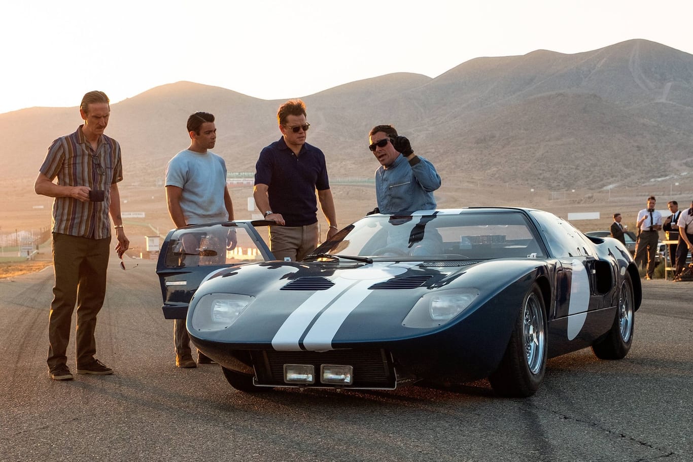 Mat Damon (2. v. r.) und Christian Bale (im Auto) bei Dreharbeiten zu "Le Mans 66": Der Ford GT40 trägt die invertierten Rennfarben der USA.