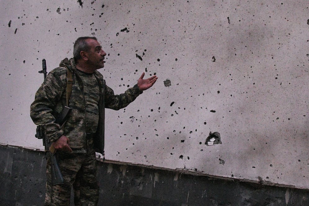 Ein Soldat deutet auf Einschusslöcher hin: Armenien wirft Aserbaidschan Gräueltaten vor.
