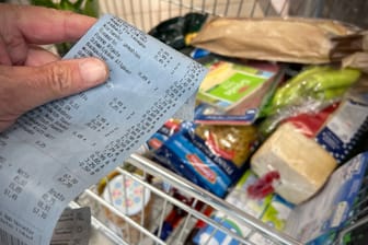 Kassenbon vor vollem Einkaufswagen: Die steigenden Preise für Lebensmittel und Energie machen den Verbrauchern zu schaffen.