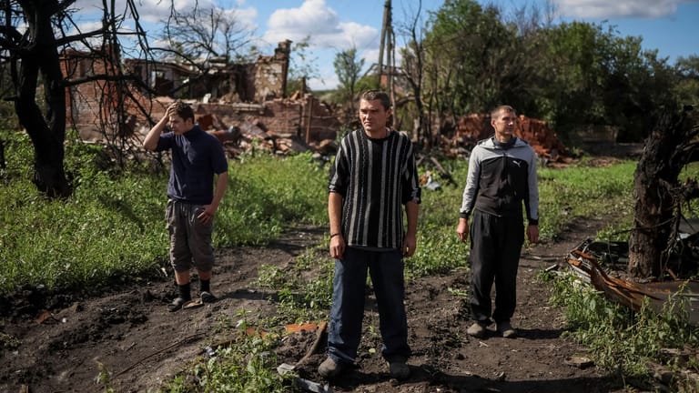 Bewohner der Stadt Kamjanka stehen vor den Ruinen ihrer Häuser: Durch Russlands Angriffe auf Wohngebiete und zivile Infrastruktur wächst die Wut auf die russischen Besatzer.