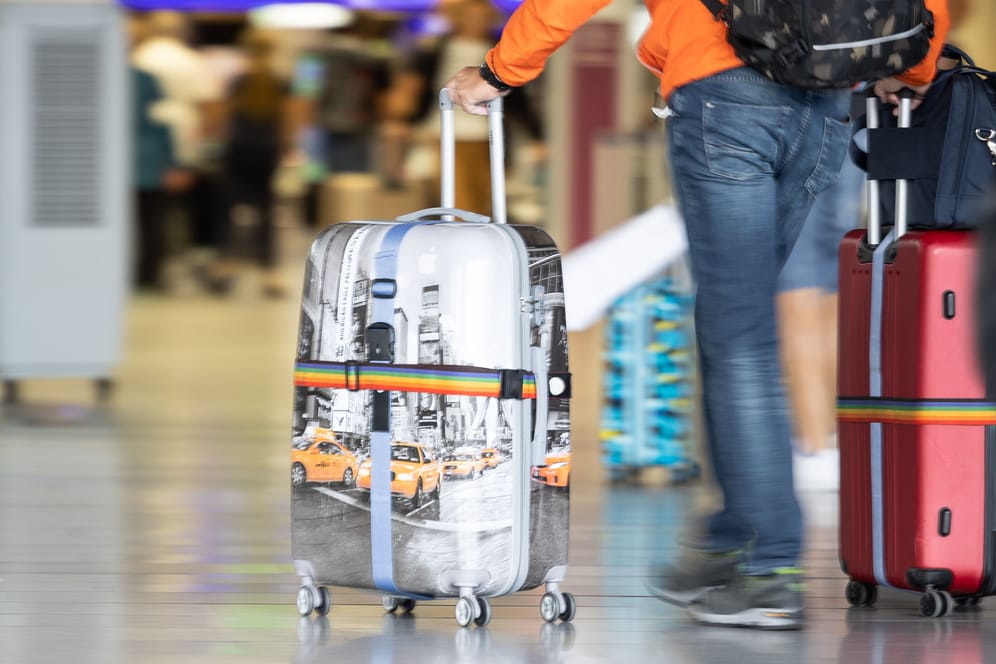 Ein Mann schiebt seinen Koffer (Symbolbild): Arbeitnehmer können nicht genommenen Urlaub aus den vergangenen Jahren mitunter noch geltend machen.