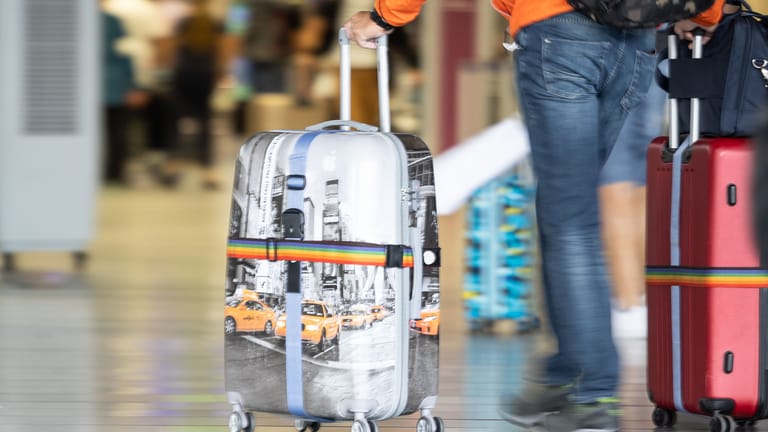 Ein Mann schiebt seinen Koffer (Symbolbild): Arbeitnehmer können nicht genommenen Urlaub aus den vergangenen Jahren mitunter noch geltend machen.