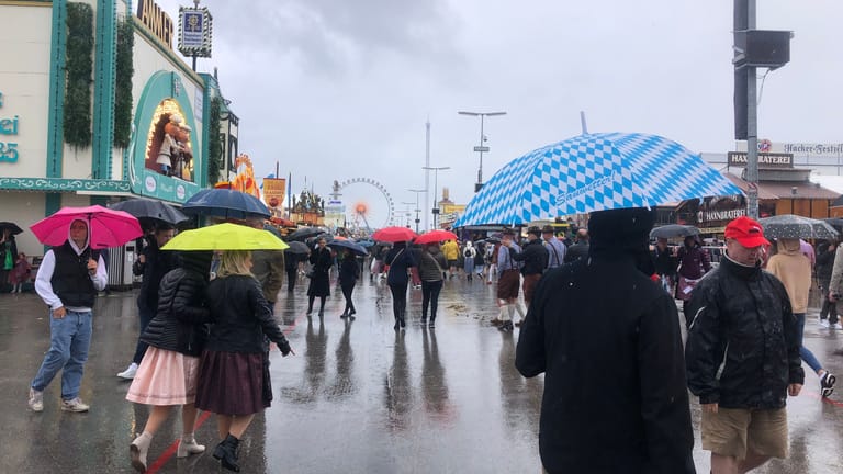 Ein Mann hält einen Regenschirm mit den bayerischen Rauten: Feuchtfröhlich wird die Wiesn heuer, auch wettertechnisch.