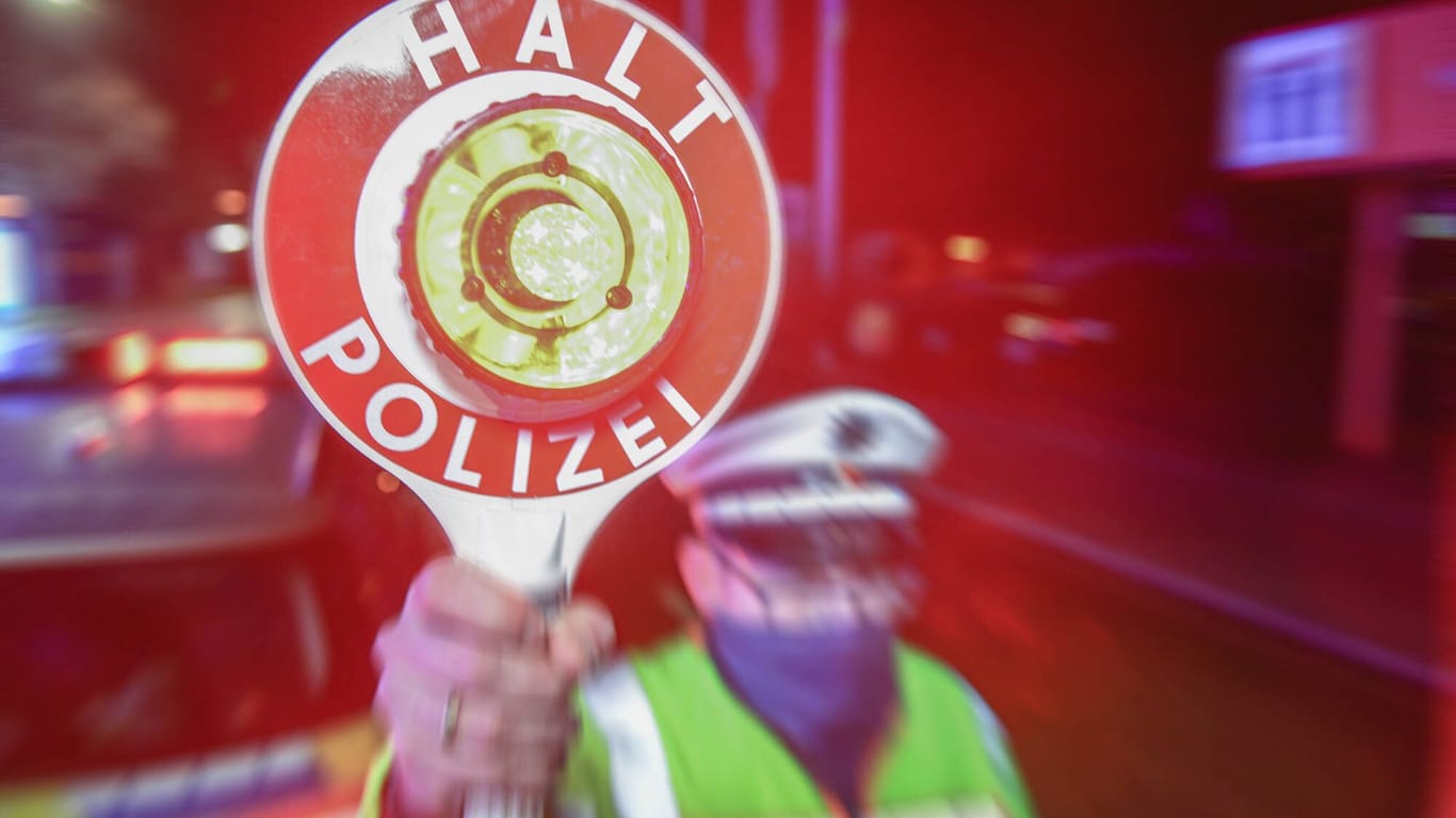 Ein Polizist mit einer Anhalte-Kelle (Symbolfoto): Die Beamten konnten den Fahrer festnehmen.