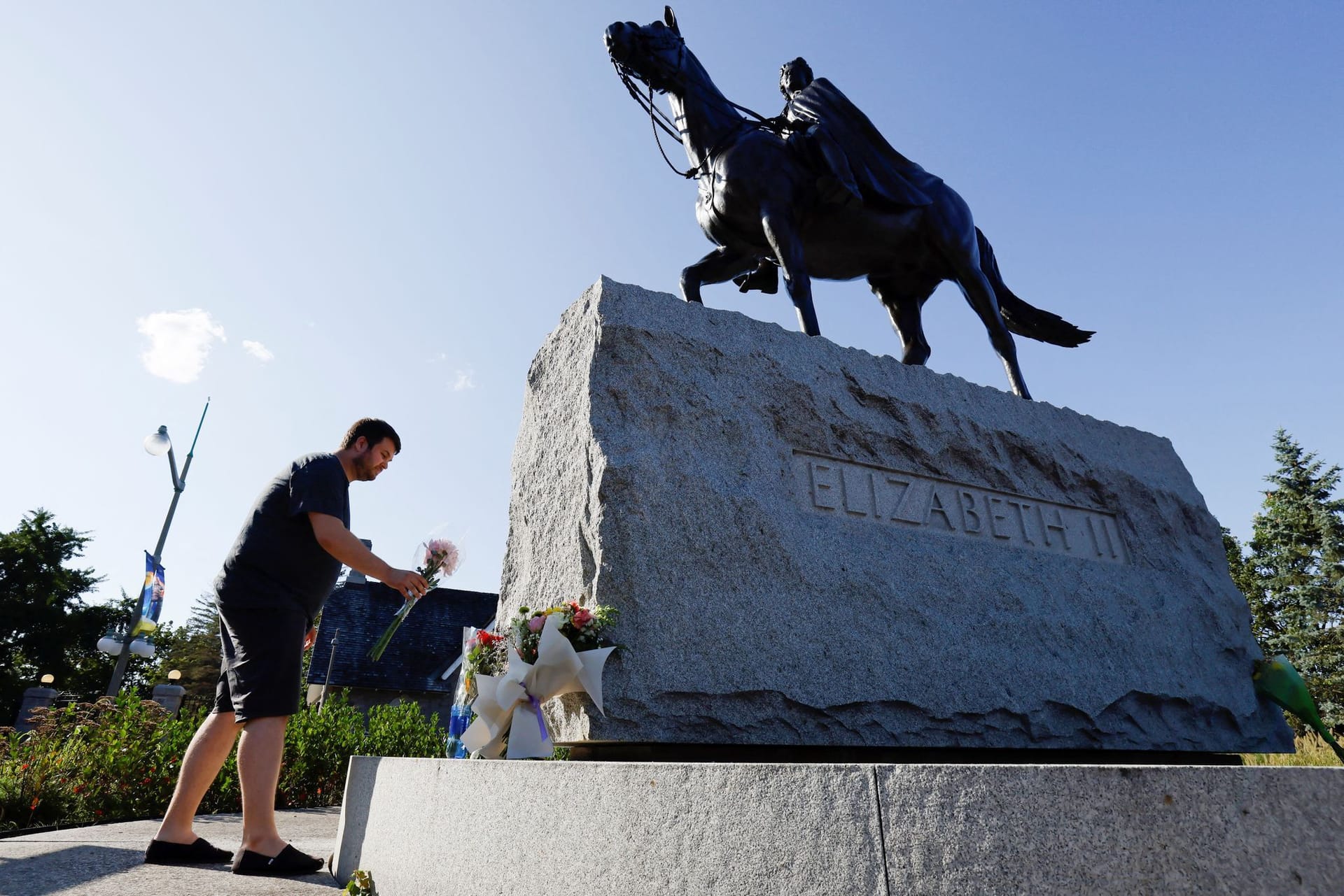 In kanadischen Hauptstadt Ottawa legt ein Mann neben einer Statue von Queen Elizabeth II. Blumen nieder.