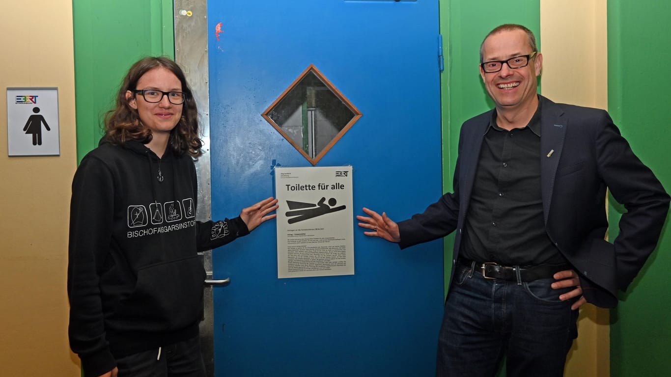Janne Brüggemann und Schulleiter Jörg Isenbeck vor einer der neuen Unisex-Toiletten des Friedrich-Ebert-Gymnasiums.