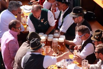 Eine Bedienung schleppt mehrere Maß Bier zu den Gästen auf dem Oktoberfest (Archivbild): Wer auf der Wiesn feiert, sollte mit Trinkgeld nicht geizen.