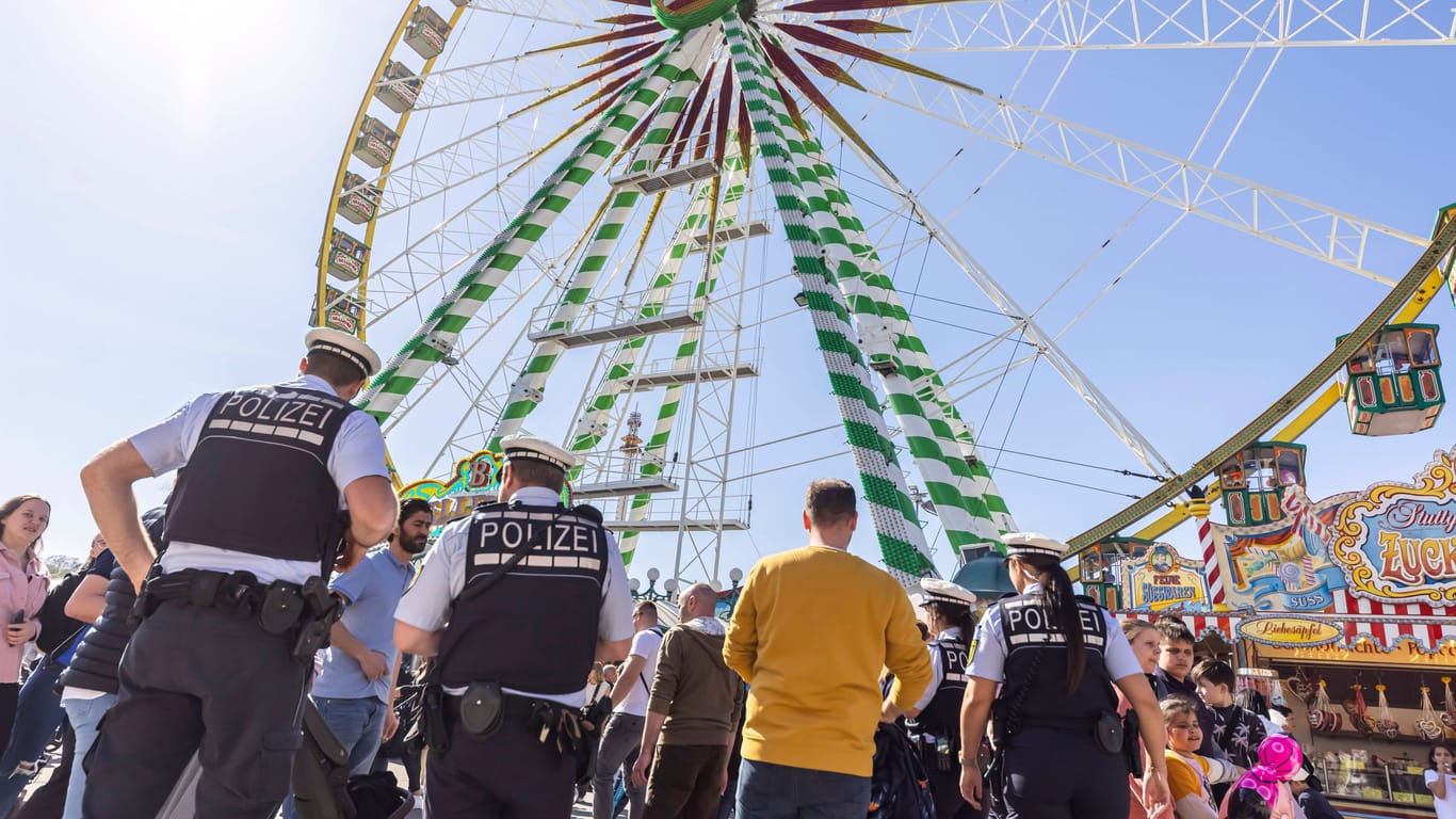 Polizisten stehen vor dem Riesenrad beim Frühlingsfest 2022 auf dem Cannstatter Wasen (Archiv): Die Polizei will auch beim Canntatter Volksfest verstärkt kontrollieren.