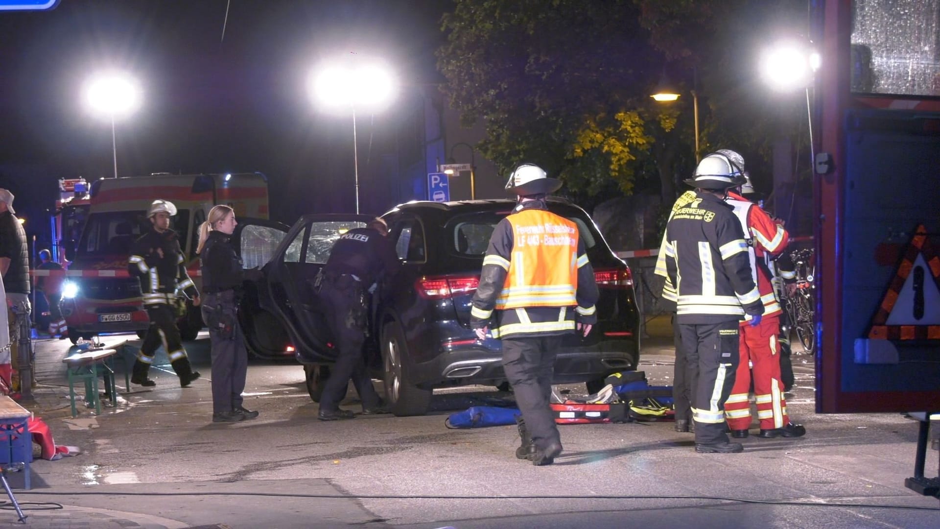 Auto fährt in Gruppe Feiernder