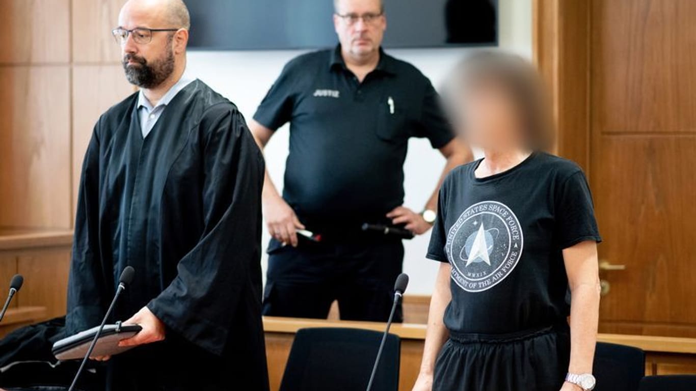 Der Angeklagte (r) steht vor Verhandlungsbeginn neben seinem Anwalt Tobias Pohl (l) im Gerichtssaal.