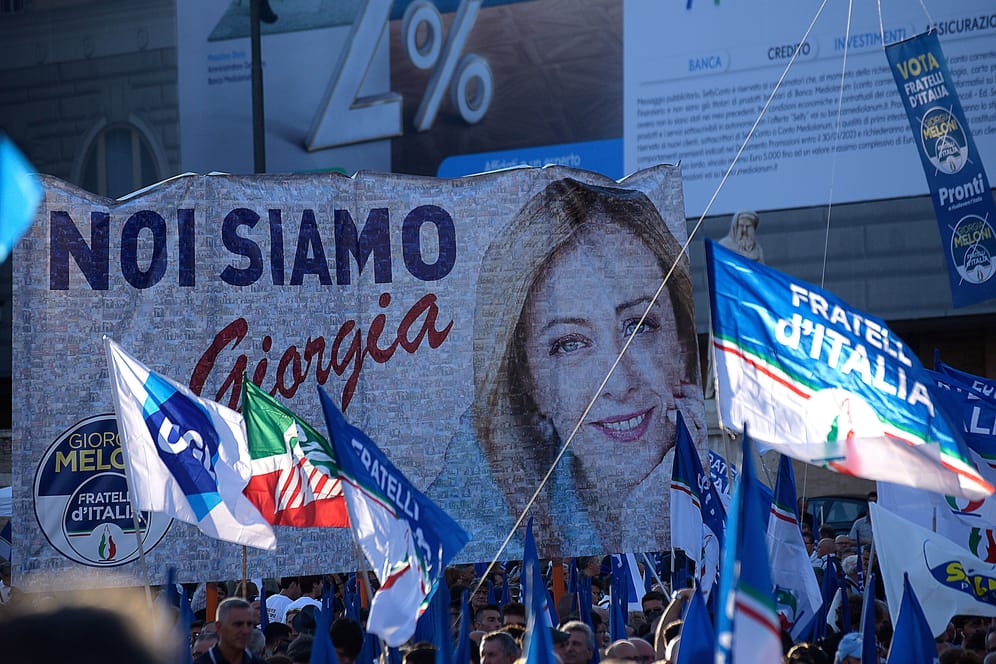 Anhänger des rechten Bündnisses bei der Abschlussveranstaltung am Donnerstag: Auf dem Plakat prankt übergroß das Gesicht der Spitzenkandidatin der Fratelli d'Italia, Giorgia Meloni.