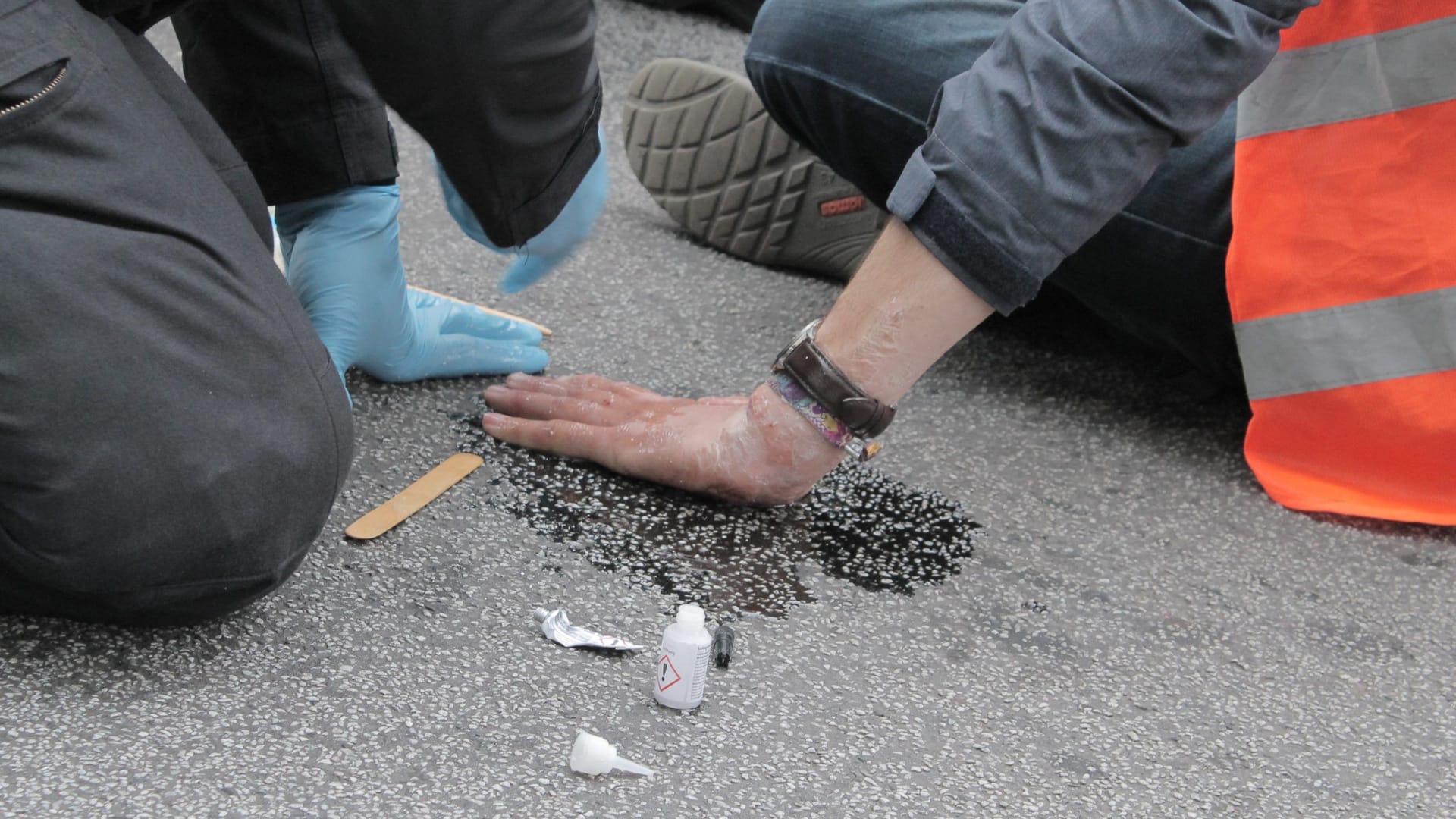 Festgeklebte Hand eines Mitglieds der "Letzten Generation" (Archivbild): Die Feuerwehr musste nach eigenen Angaben improvisieren, weil ein Spezialfahrzeug nicht durchkam.