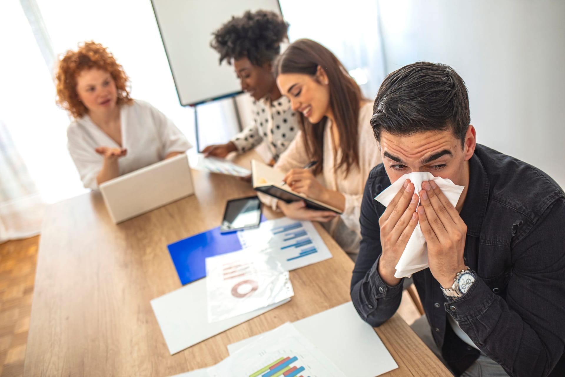 Erkälteter Mann bei der Arbeit im Büro