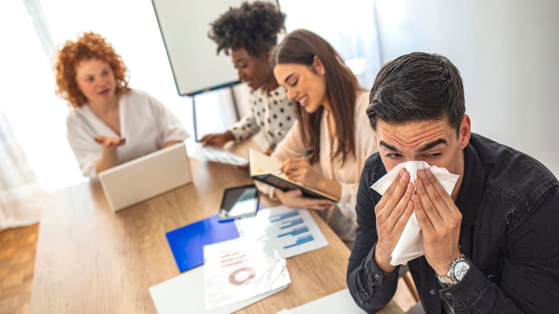 Erkälteter Mann bei der Arbeit im Büro