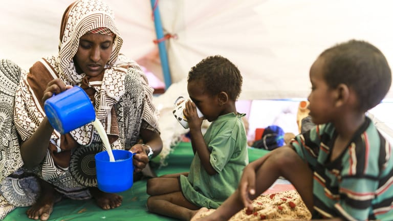 Eine Mutter bereitet ihren Kindern Milch aus Milchpulver bei einer Unicef-Speisung in einem Dorf an der Grenze zwischen Äthiopien und Somalia: In Afrika und Südasien ist die Hungersituation besonders ernst.