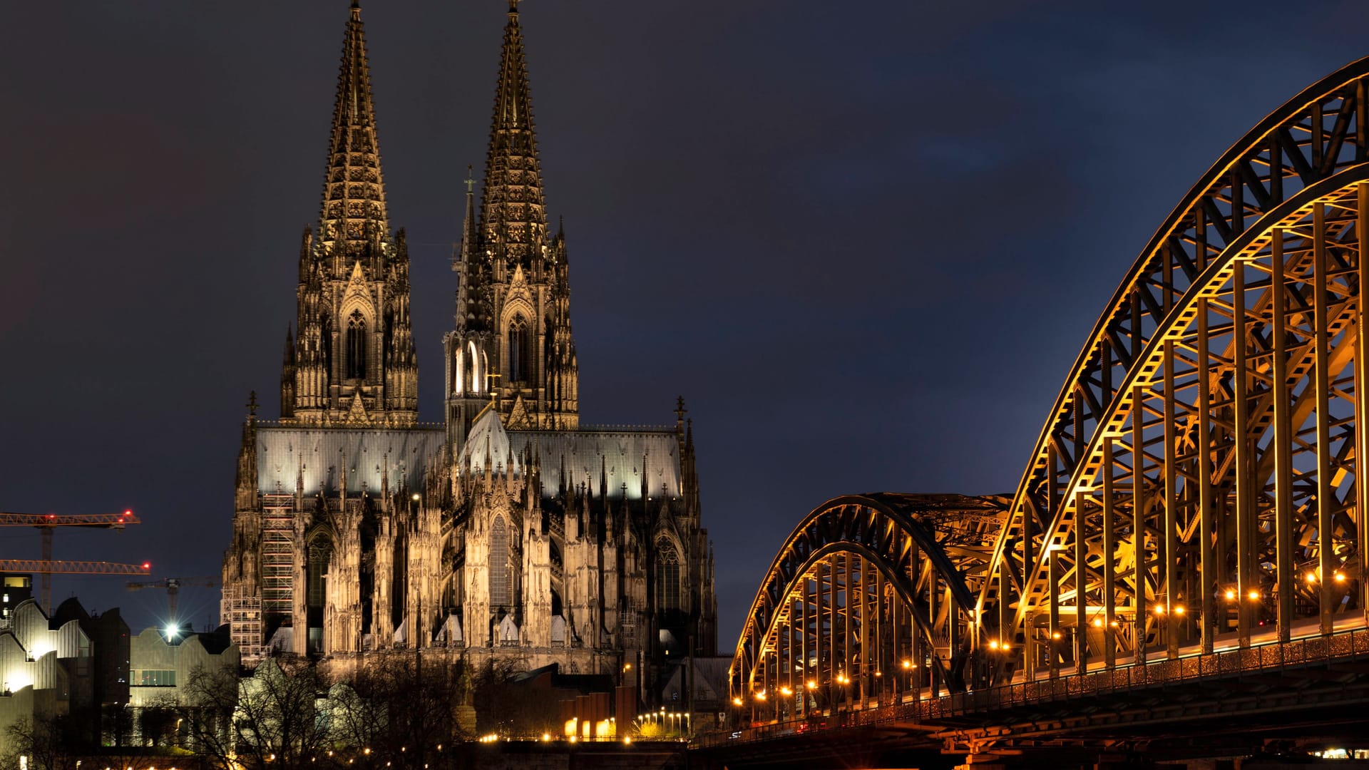 Der Kölner Dom und die Hohenzollernbrücke bei Nacht (Archivbild): Die LED-Beleuchtung am Dom soll zumindest teilweise wieder angeschaltet werden.